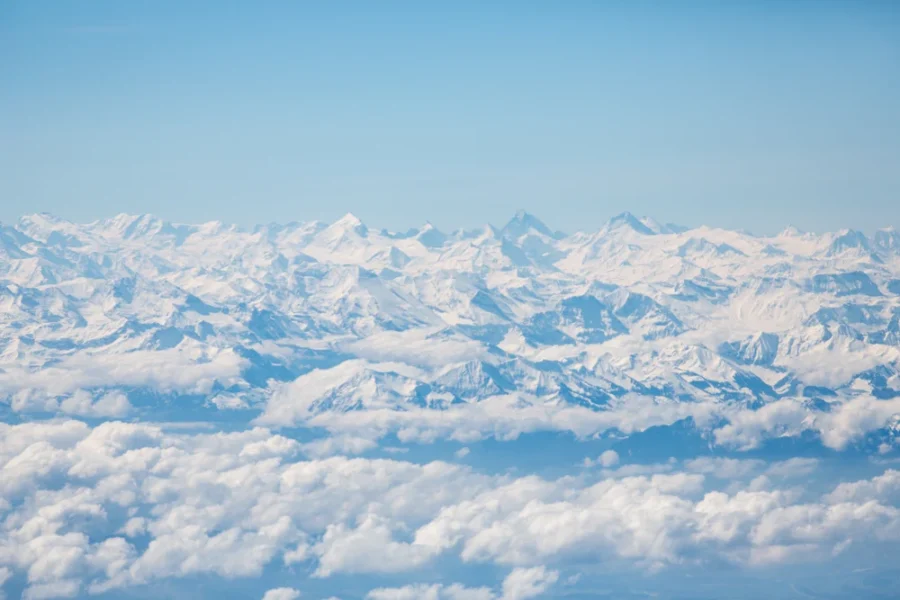 swiss alps view from over clouds photo by kobi schutz